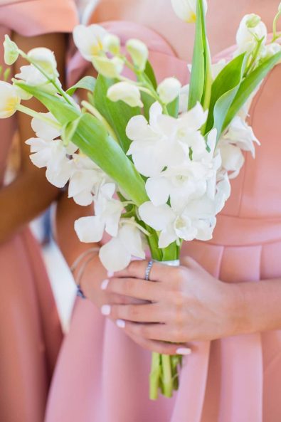 Close up shot of bridesmaid's flower bouquet with white orchids and white tulips.