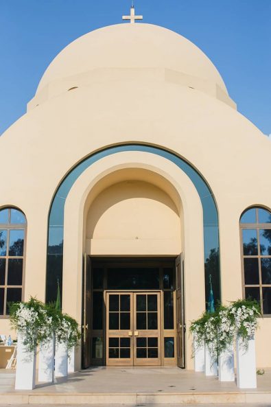 Panagia Faneromeni church in Vouliagmeni Athens with white orchid entryway floral arrangements.