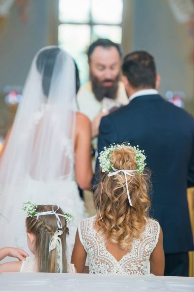 Flower girls with lacy white dresses and flower crowns.