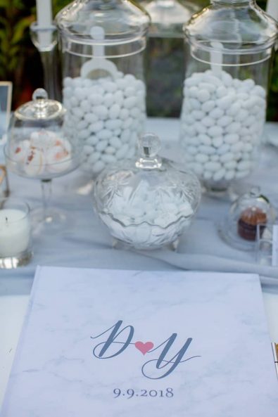Personalized custom made wedding wish book and sugar-coated almond in crystal and glass serving bowls.