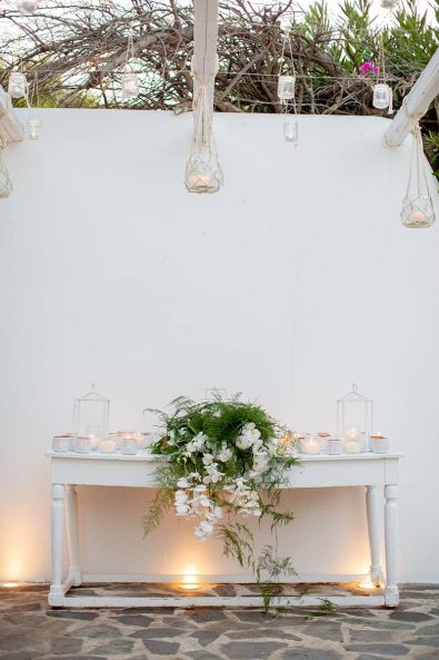 Vintage white entryway wooden table with candles and flower decorations.