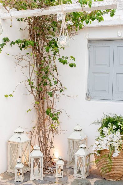 Minimal and chic island chic wedding venue decoration with white wooden lanterns and white candles in the Athenian Riviera.
