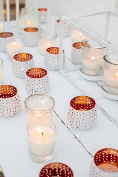 Detail shot of white and copper candle holders and white clear candle holder with white paraffin candle.