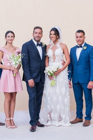Group shot of groomsmen, bridesmaids, groom, and bride after the wedding ceremony at a destination wedding in athenian riviera.