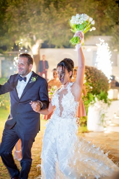 Bride and groom entering their wedding party reception after their destination wedding in athenian riviera.