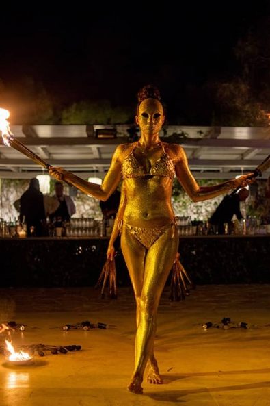 Gold body-painted female dancers for a wedding fire dance show.