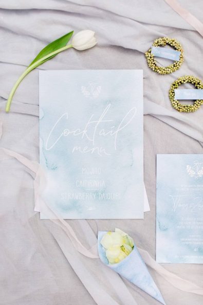 Detail shot of wedding stationery and custom-made wedding cocktail menu in a light blue watercolor paper.