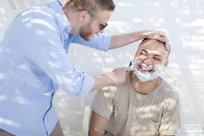 The groom`s best friend shaving him before the wedding ceremony according to the Greek wedding traditions.