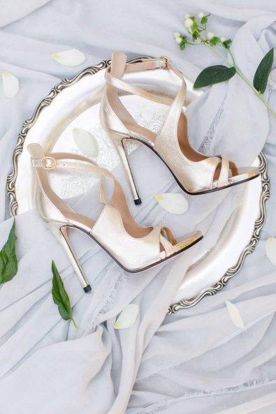 Elopement for the bride - Champagne gold wedding shoes on a vintage silver serving tray with light blue fabric and rose petals for a destination wedding in Greece.