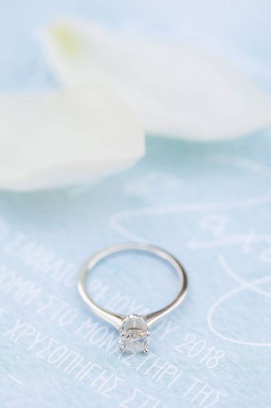 White gold diamond ring on the light blue watercolor wedding invitation.