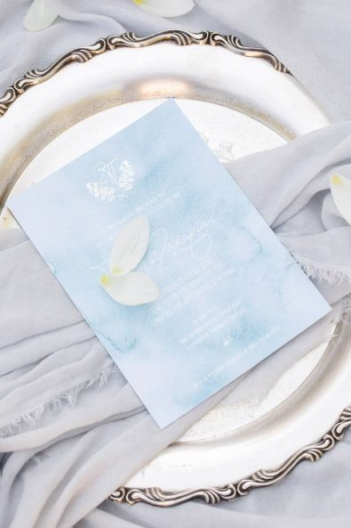Fine art shot of wedding invitation on a silver serving tray.