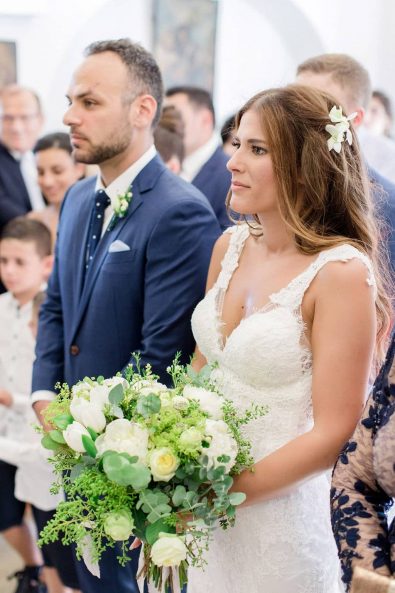 Bride and groom next to each other in the church during a greek orthodox wedding ceremony in Greece.