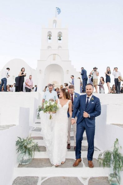 Happy and smiling bride and groom exiting the church with their friends and family.