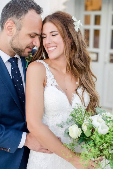Close up shot of groom holding lovingly the bride after a summer wedding in Greece.