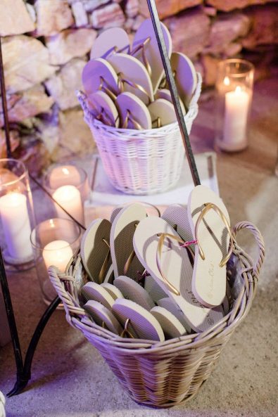 Dancing flipflops for wedding guests to dance with, in a wooden basket.