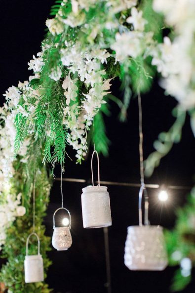 Hanging candle lanterns and white flowers wedding decorations.