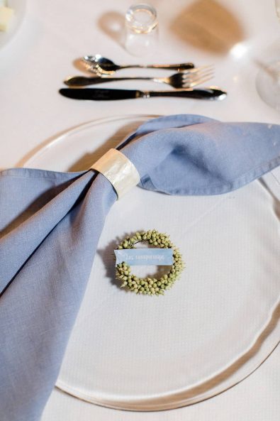 Close up shot of light blue linen napkin with thank you note in a little flower wreath.