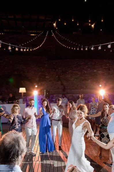 Bride dancing with her guests traditional greek group dances.