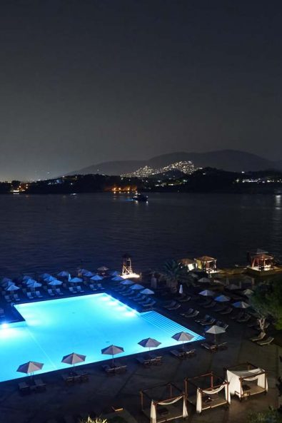 Luxury christening party venue in the nighttime with a pool and sunbeds.