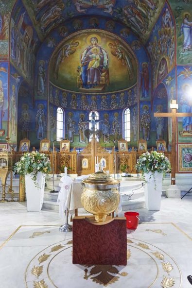 Orthodox Church Baptism and gold baptistery with flower arrangement decorations for a Greek orthodox baptism.
