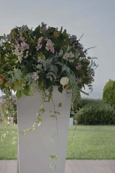 Greek orthodox baptism flower arrangements with summer flowers and vine.