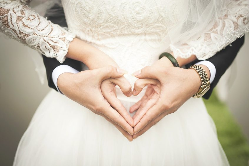 couple hugging and making the heart symbol with hands