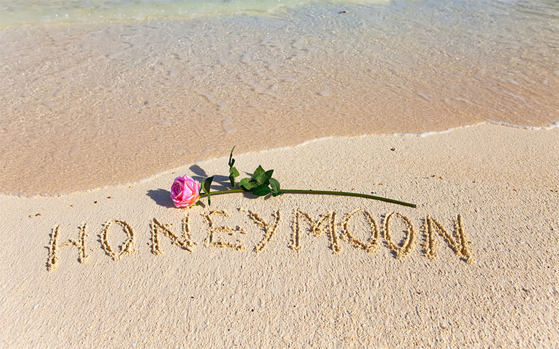 Honeymoon written on the sand