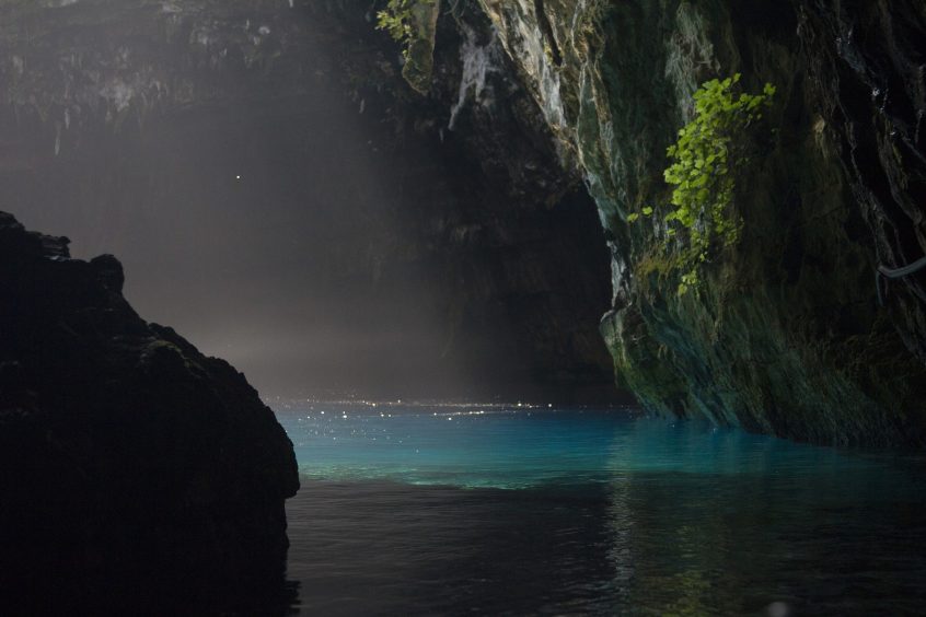 Dark forest lake with light shining