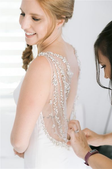 Bride getting dressed by bridesmaid