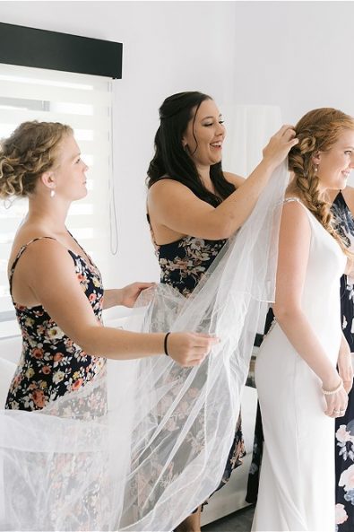 Bridesmaids dressing the bride