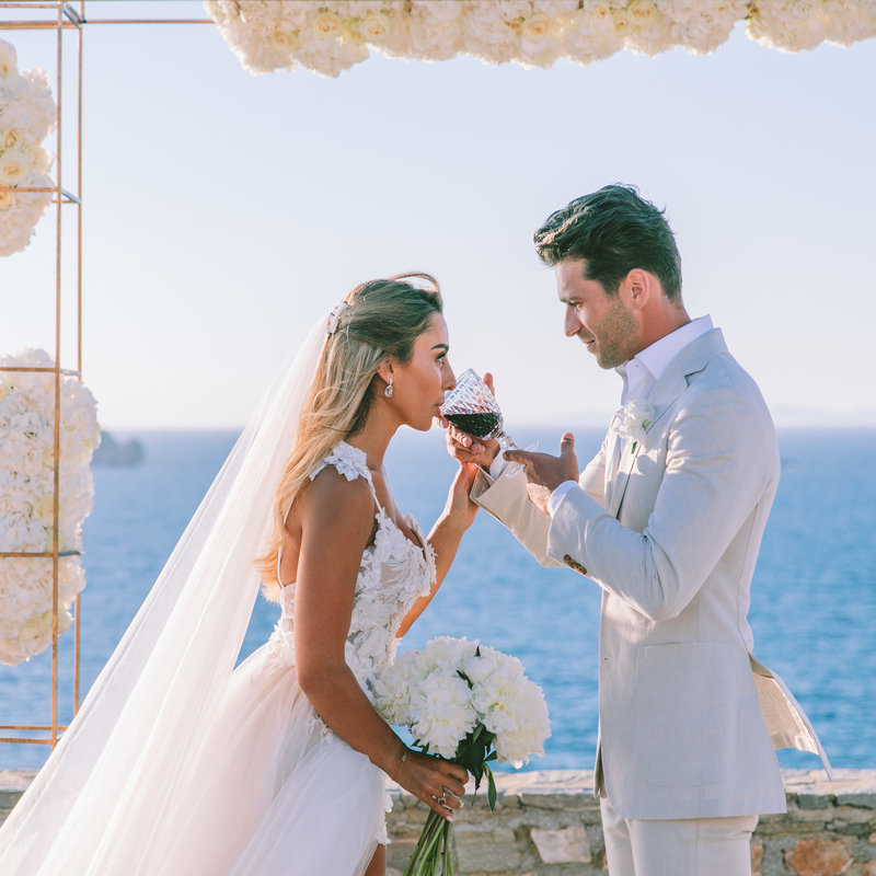 photo of bride and groom sipping wine